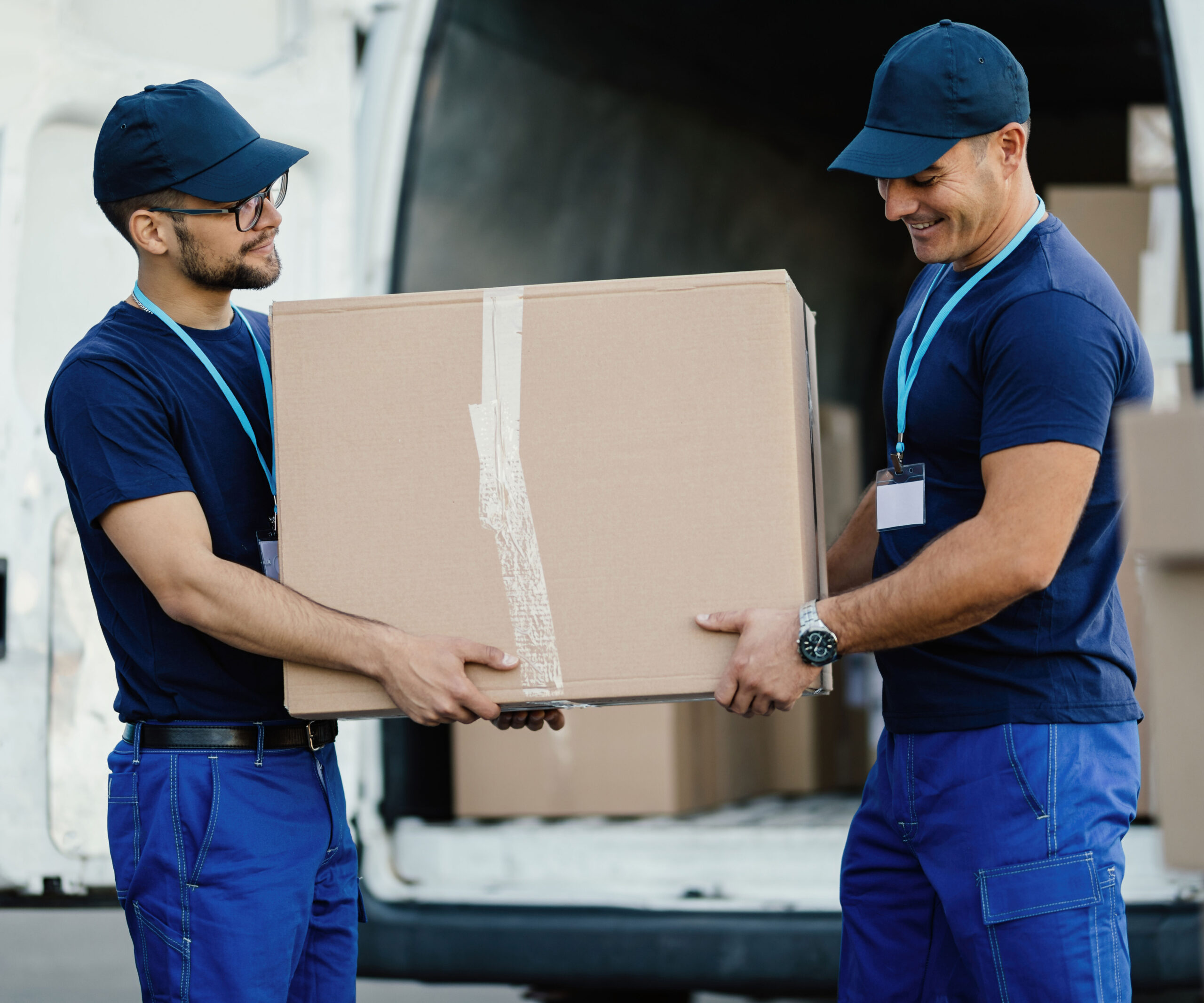 Summit County movers working together to lift heavy furniture and boxes from a truck into a home.