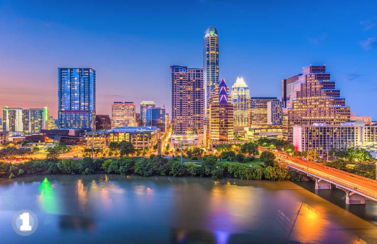Austin skyline at dusk with colorful reflections on the river.