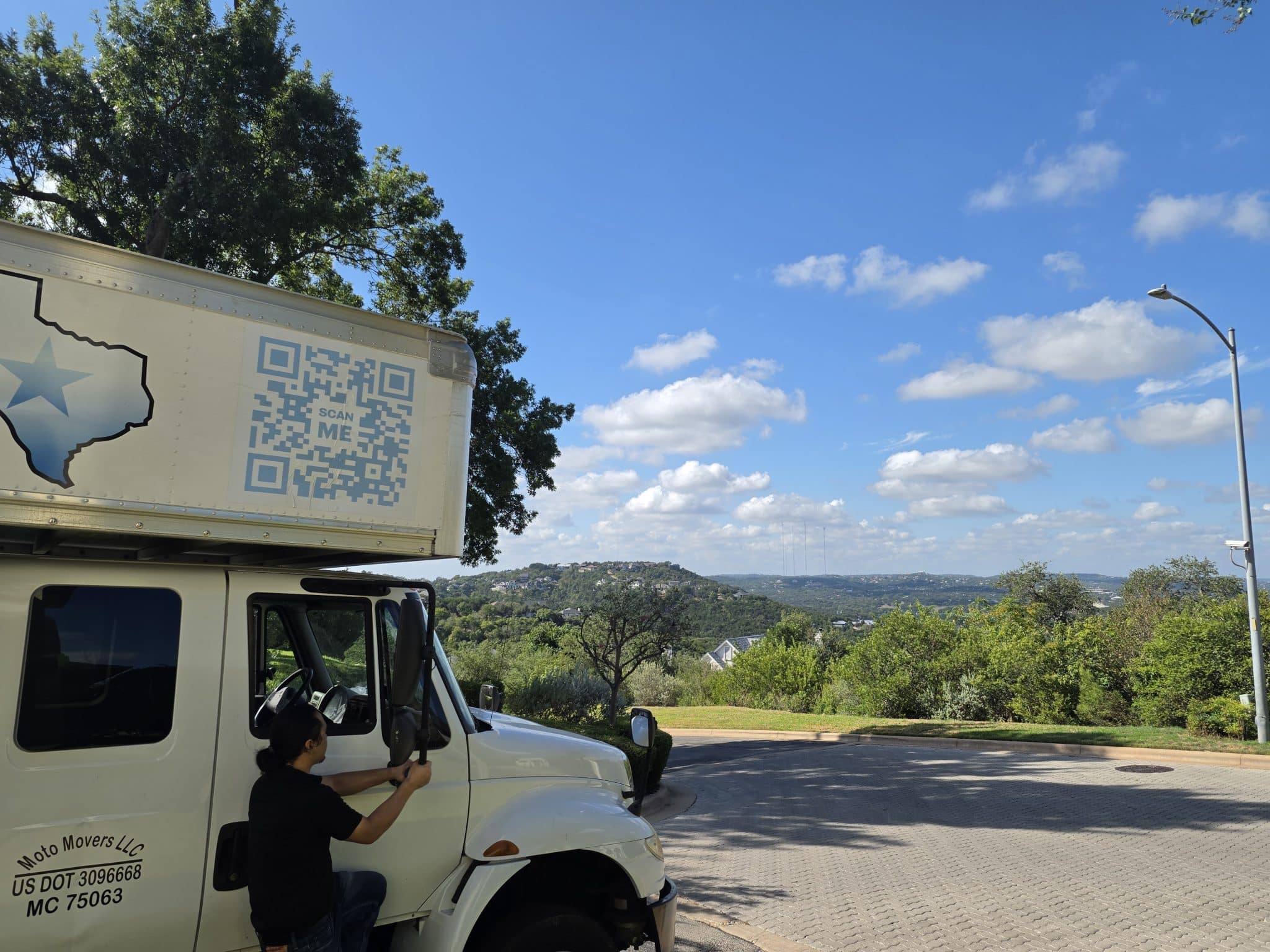 Moto Movers at hillside home in Austin Moto Movers moving truck and mover at a residential home in the hills of west Austin, Texas.