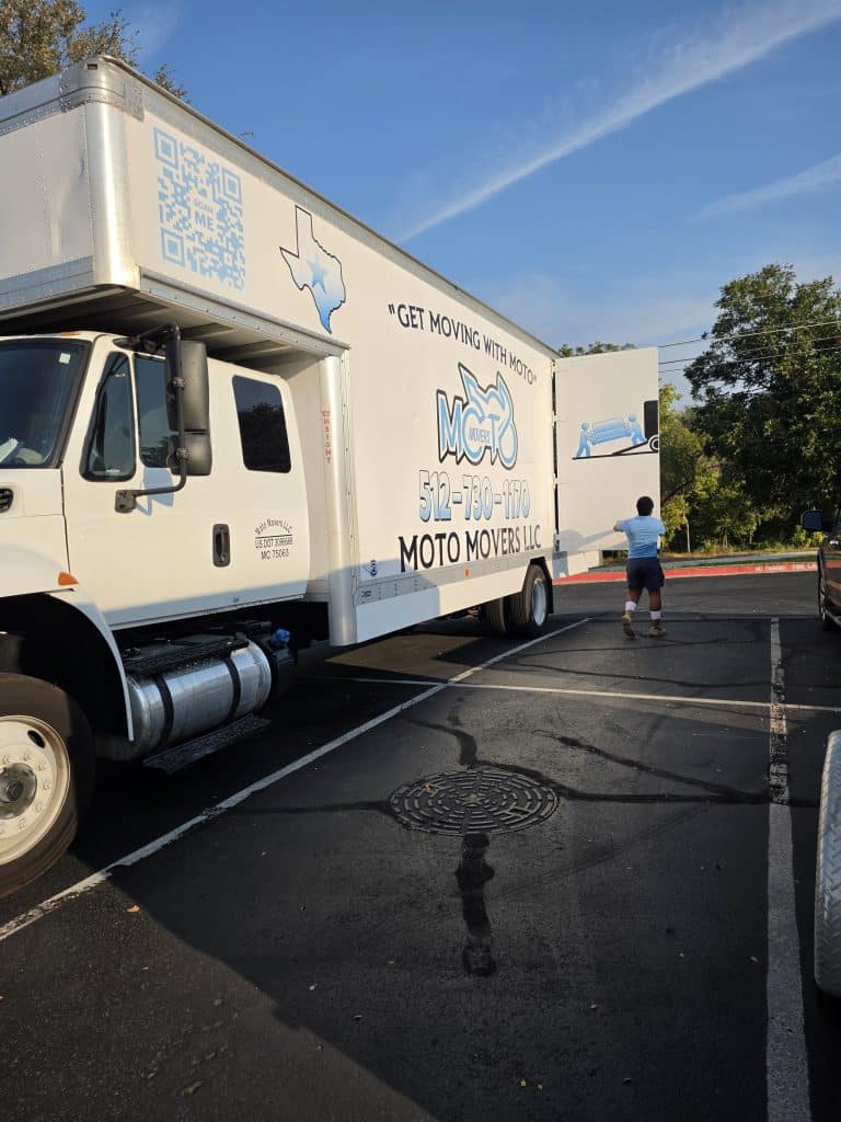 Moto Movers at home office lot in Round Rock, Texas. Moto Movers closing door of moving truck in the parking lot of their Round Rock, Texas company headquarters.