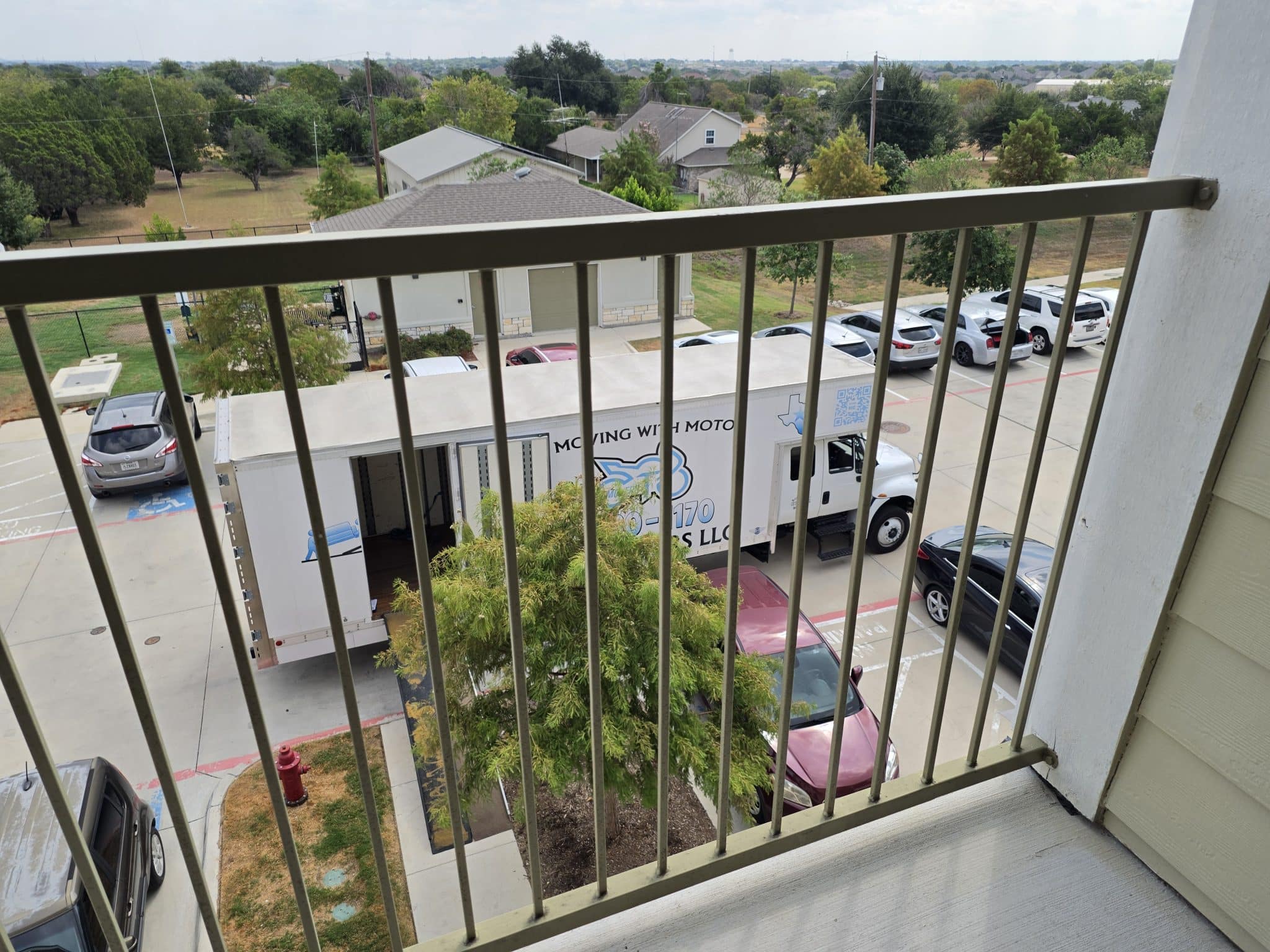 Moto Movers at Round Rock apartment building View from balcony overlooking parked Moto Movers moving truck in Round Rock, Texas.