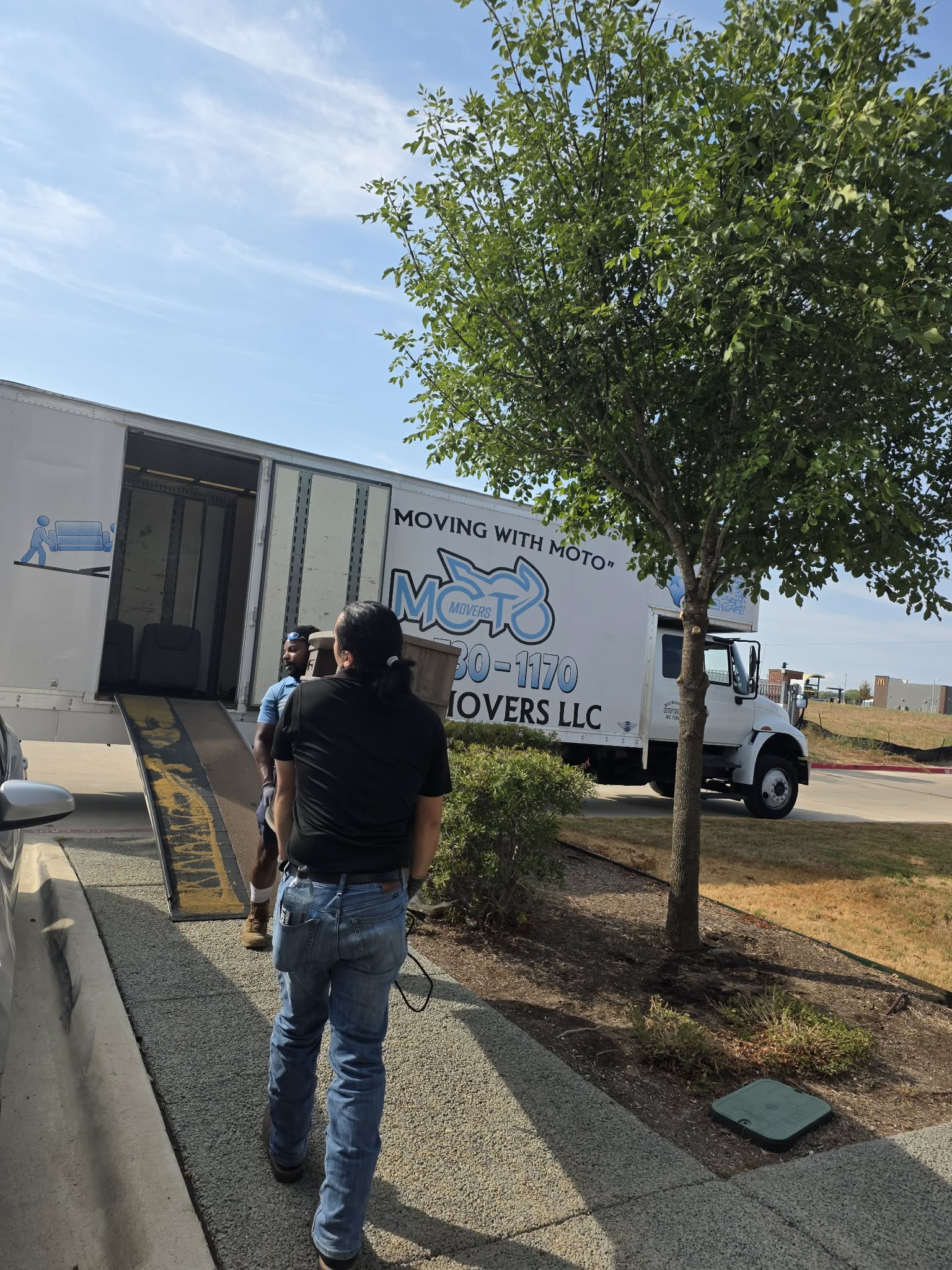 Moto Movers loading furniture at apartment in Georgetown, TX Moto Movers loading furniture onto a moving truck on a sunny day in Georgetown, Texas.